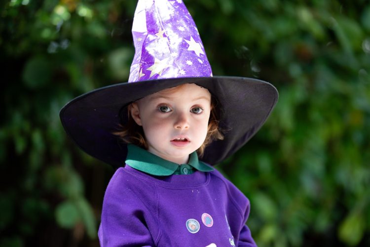 child with wizard hat on outside