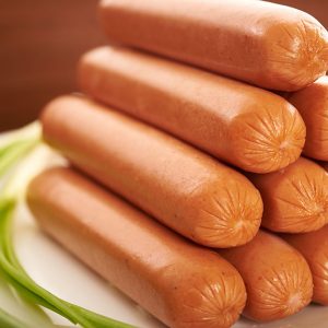 sausage on a white plate on a wooden table